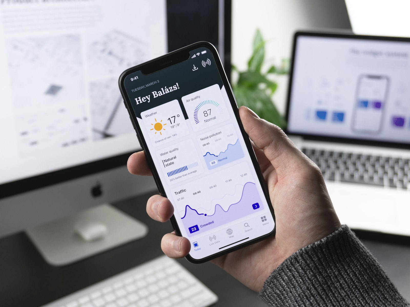 Hand holding a phone running an app
